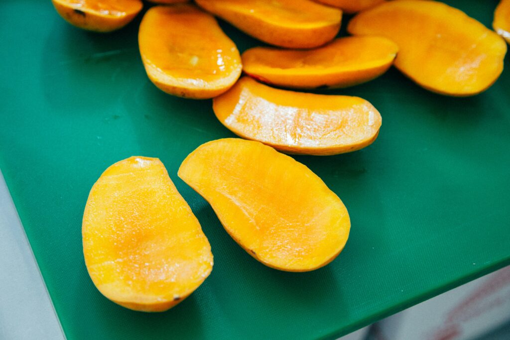Sliced mango pieces on green surface