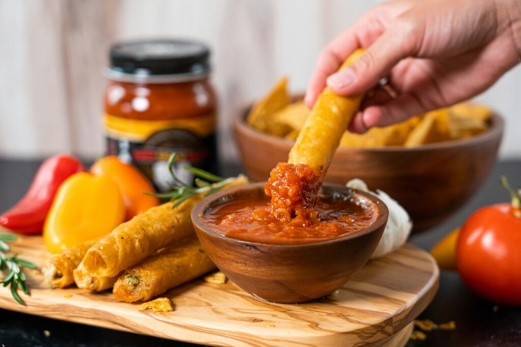 Hand dipping food into sauce