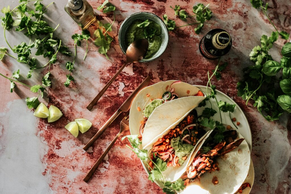 Tacos topped with sliced meat and herbs