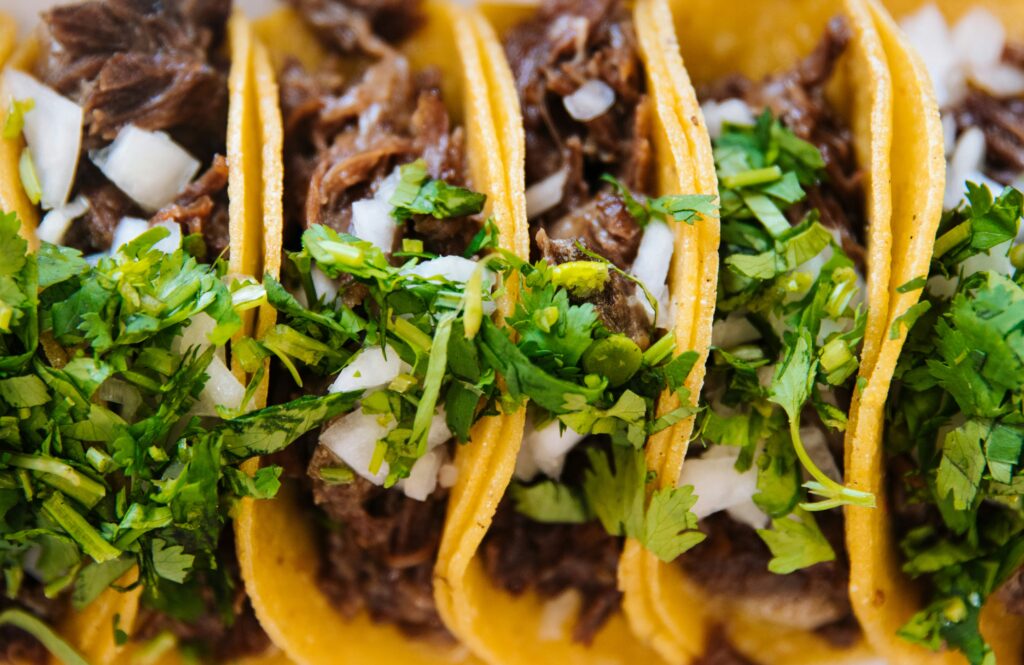 Close-up of tacos filled with shredded meat, onions, and cilantro